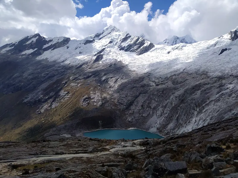 Turquoise Taullicocha lake below glaciers, seen from Punta Unión pass